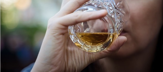 A person tasting a sip of whiskey