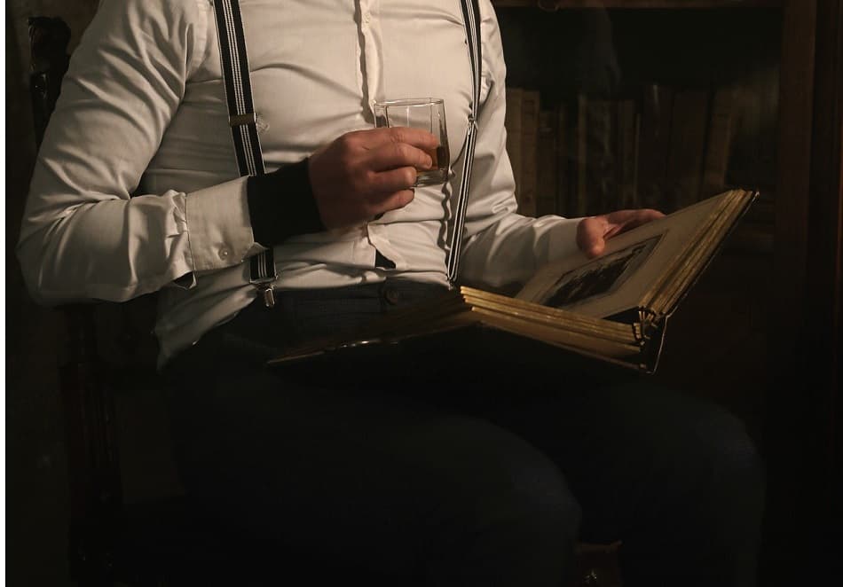 A man taking his time drinking a glass of whiskey