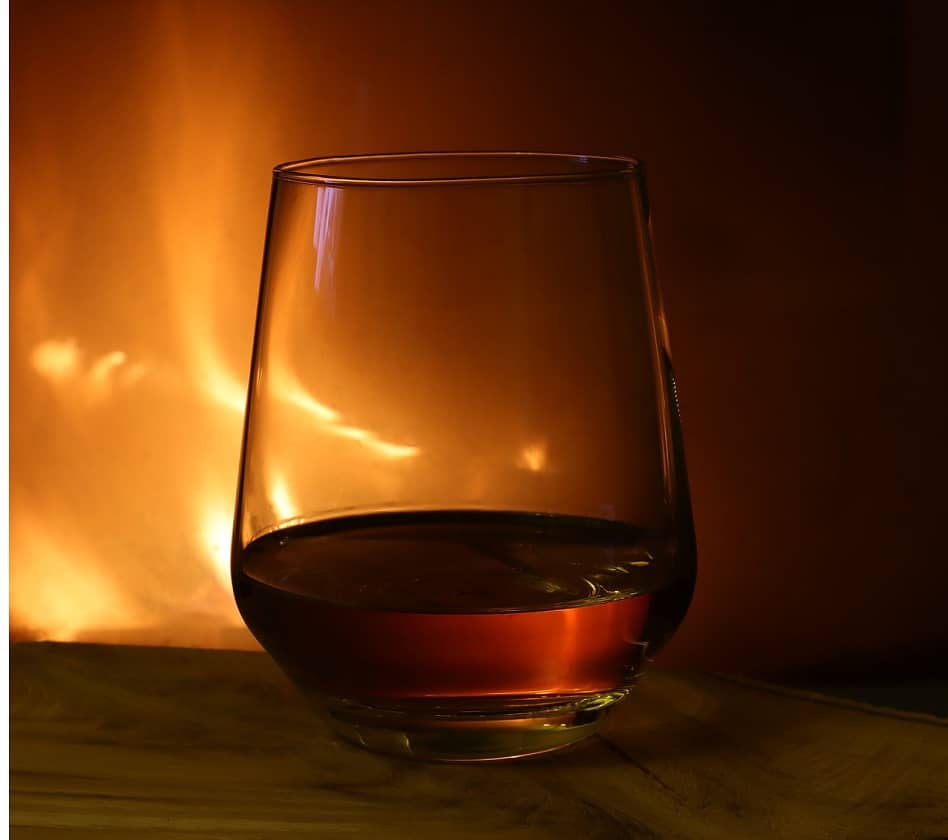 Whiskey glass in front of a fire