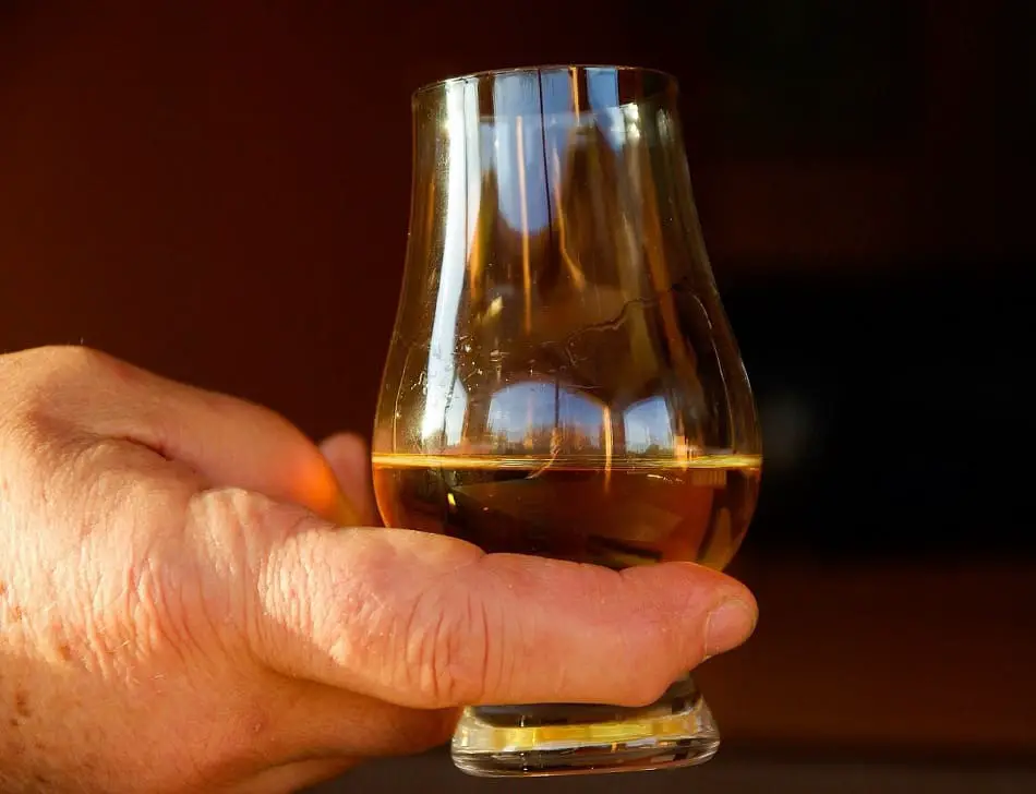A man holding a Glencairn whisky glass