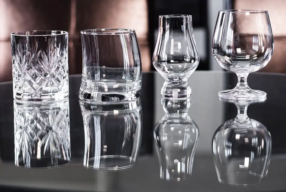 4 whiskey glasses and their reflections