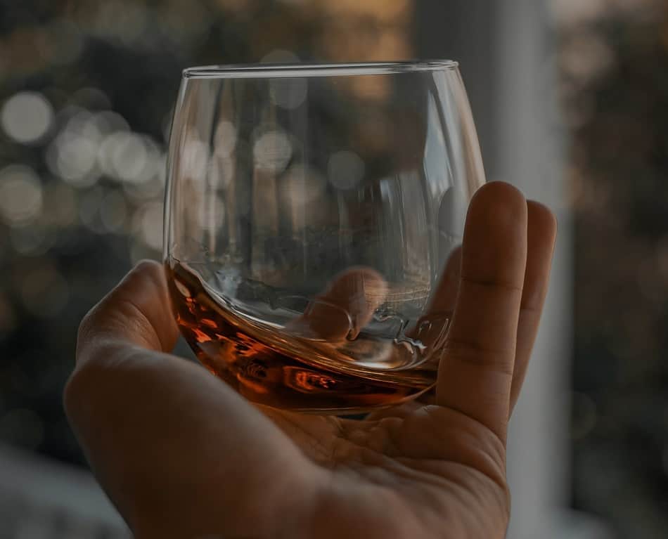 Whiskey glass held in the palm of a hand