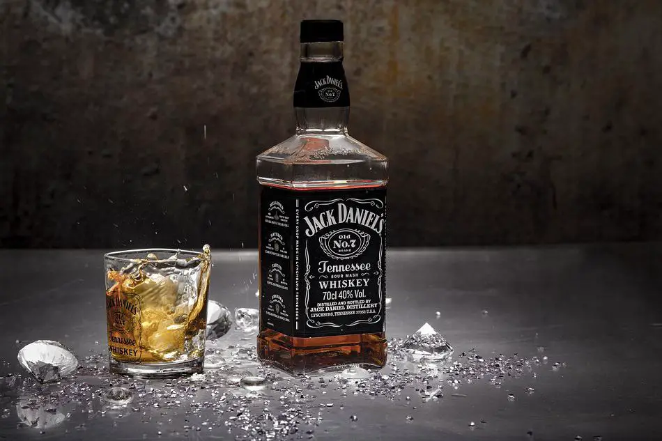 A glass of whiskey and a bottle of Jack Daniel’s surrounded by diamonds