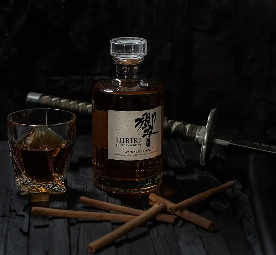 A glass of whisky, a bottle of Hibiki Suntory Whisky and a sword
