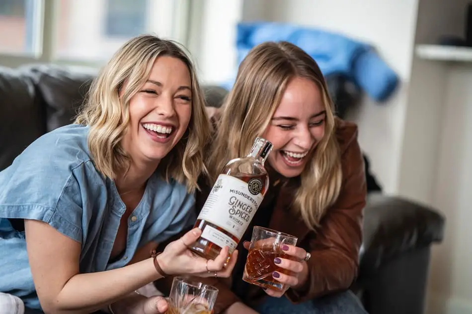 Two people enjoying a drink of whiskey