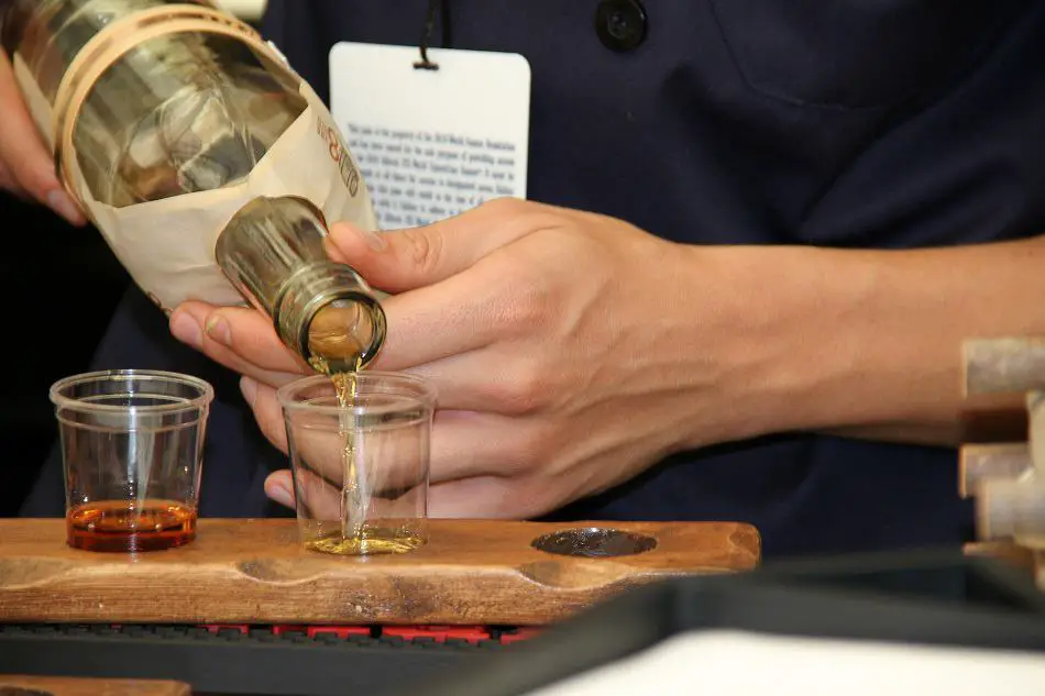 Man pouring shots of whiskey from a bottle