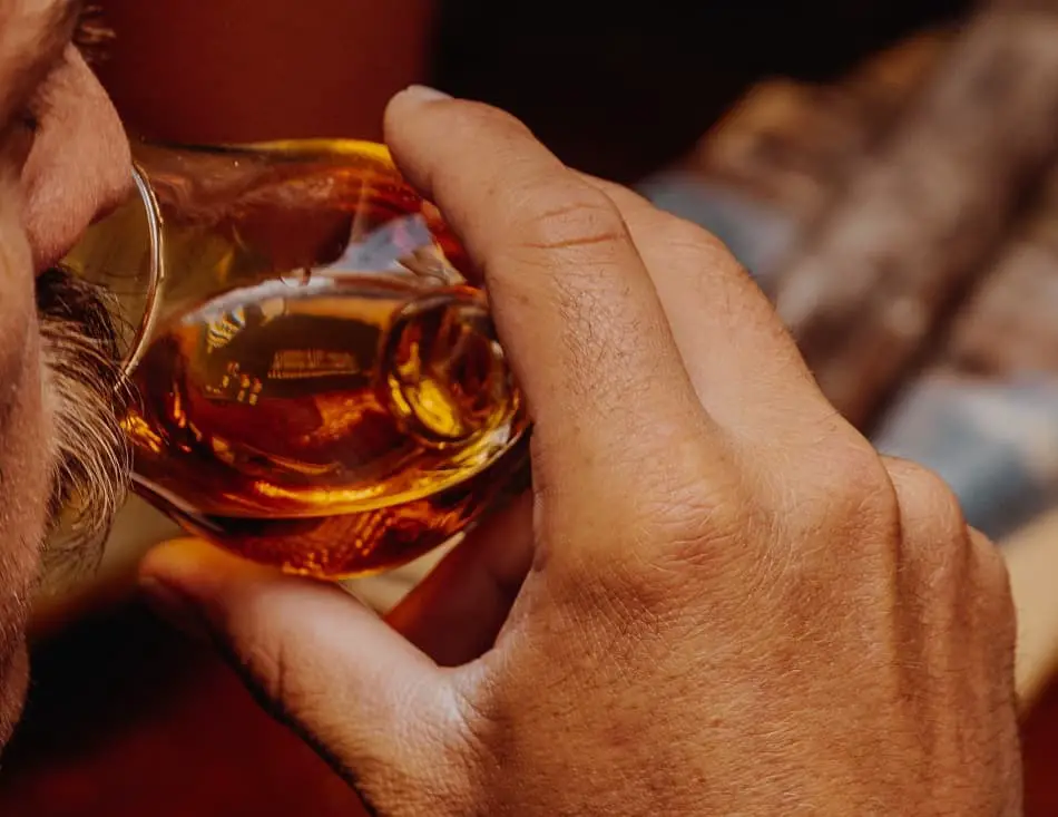 Man nosing different parts of his glass