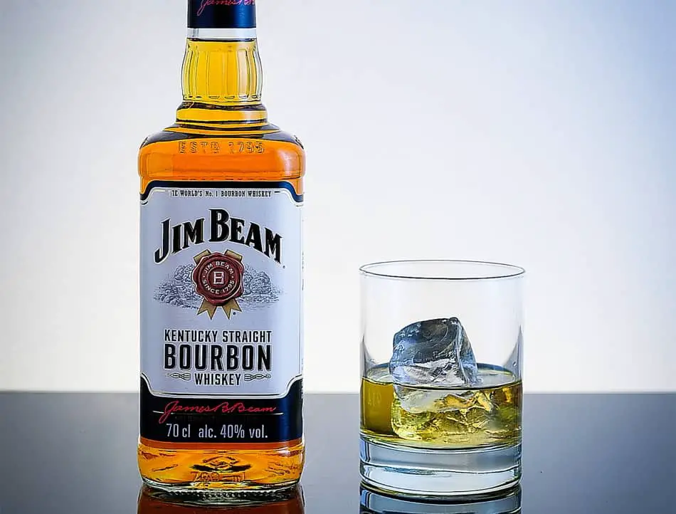 A bottle of Jim Beam and a glass of whiskey with ice