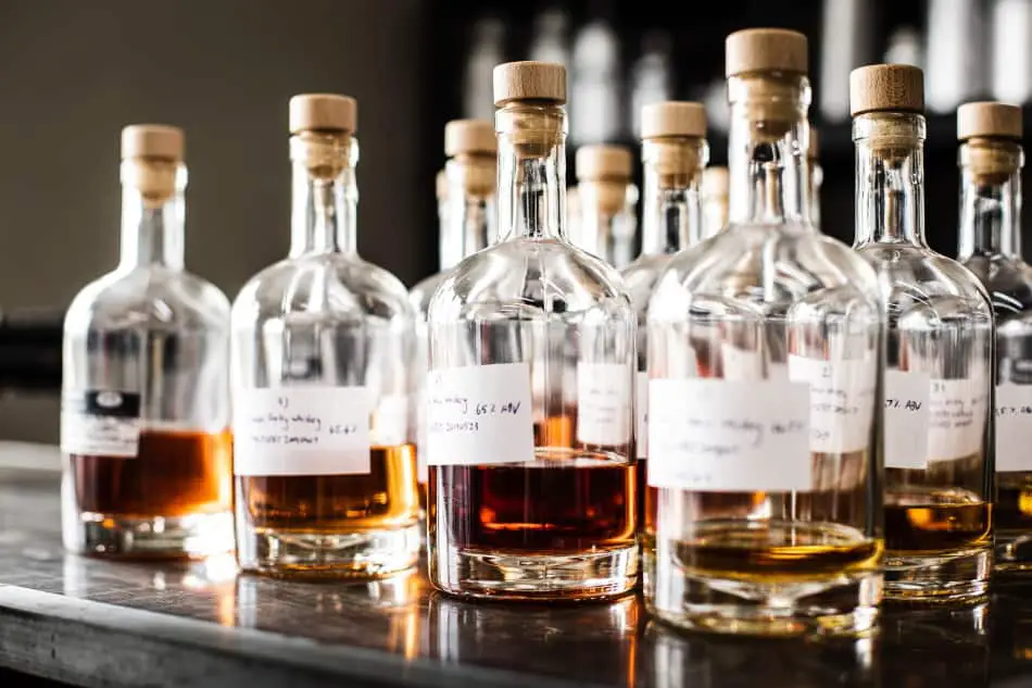 Glass bottles with whiskey waiting to be blended