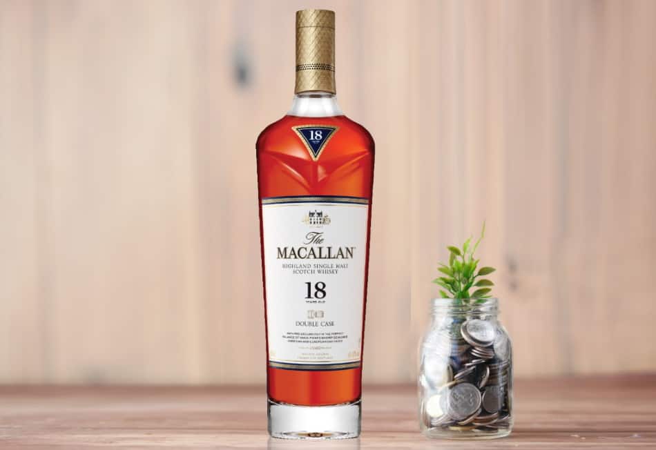 A bottle of Macallan Double Oak 18 next to a jar of coins
