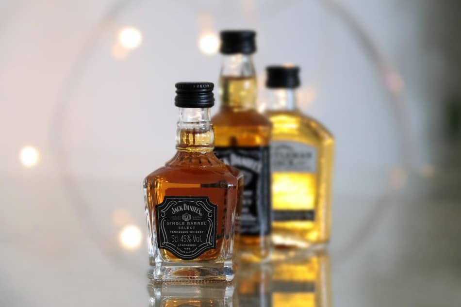 Three different bottles of Jack Daniel’s whiskey standing upright where they’re being displayed