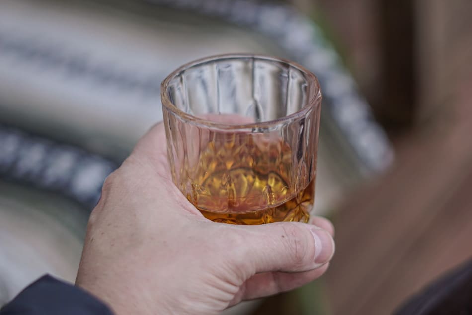 Whiskey tumbler being held by the base