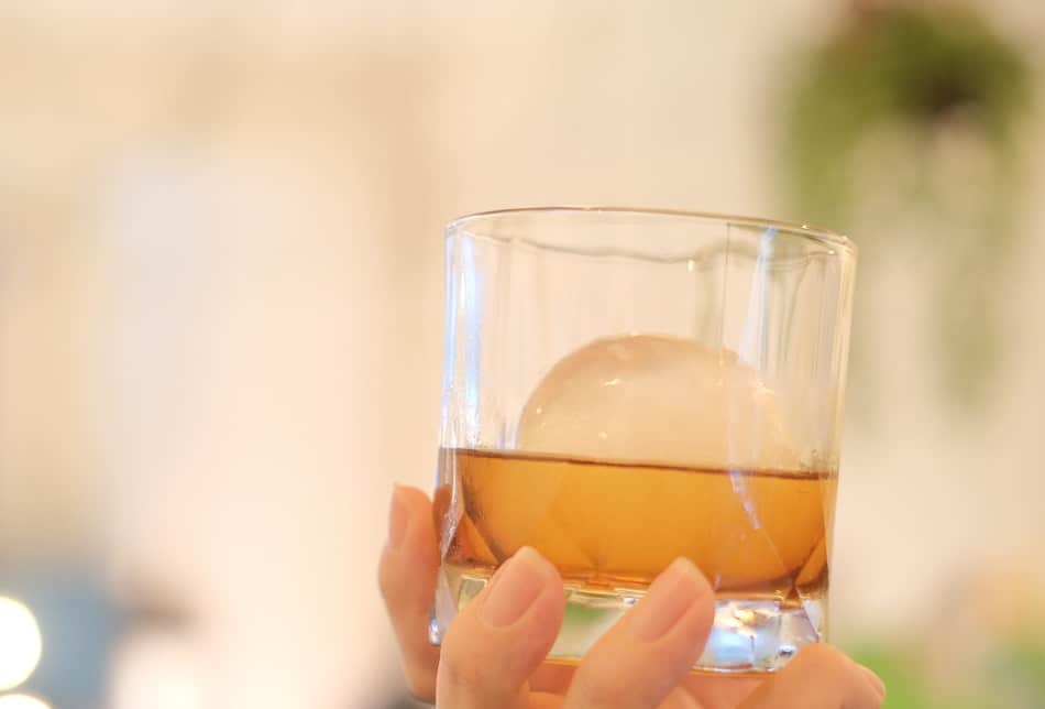Whiskey in a whiskey tumbler with a giant ice cube