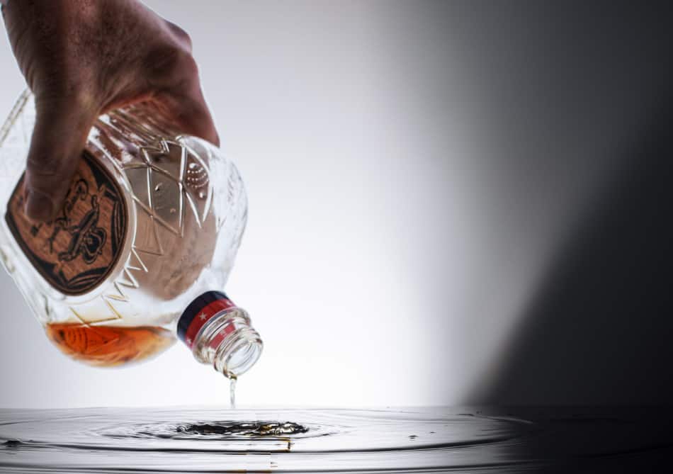 Man pouring out a bottle of Crown Royal whiskey