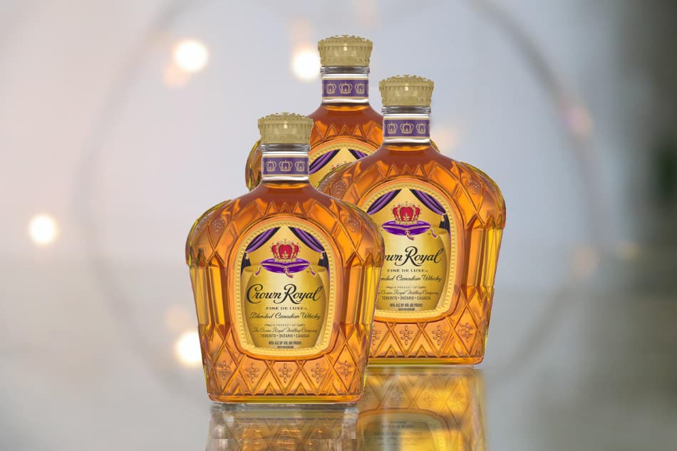Three different bottles of Crown Royal whiskey standing upright where they’re being displayed